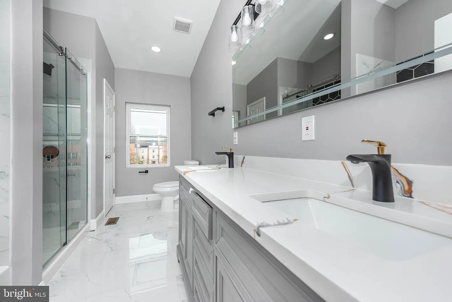 Hollins Market spa bathroom with marble tile and frameless glass shower